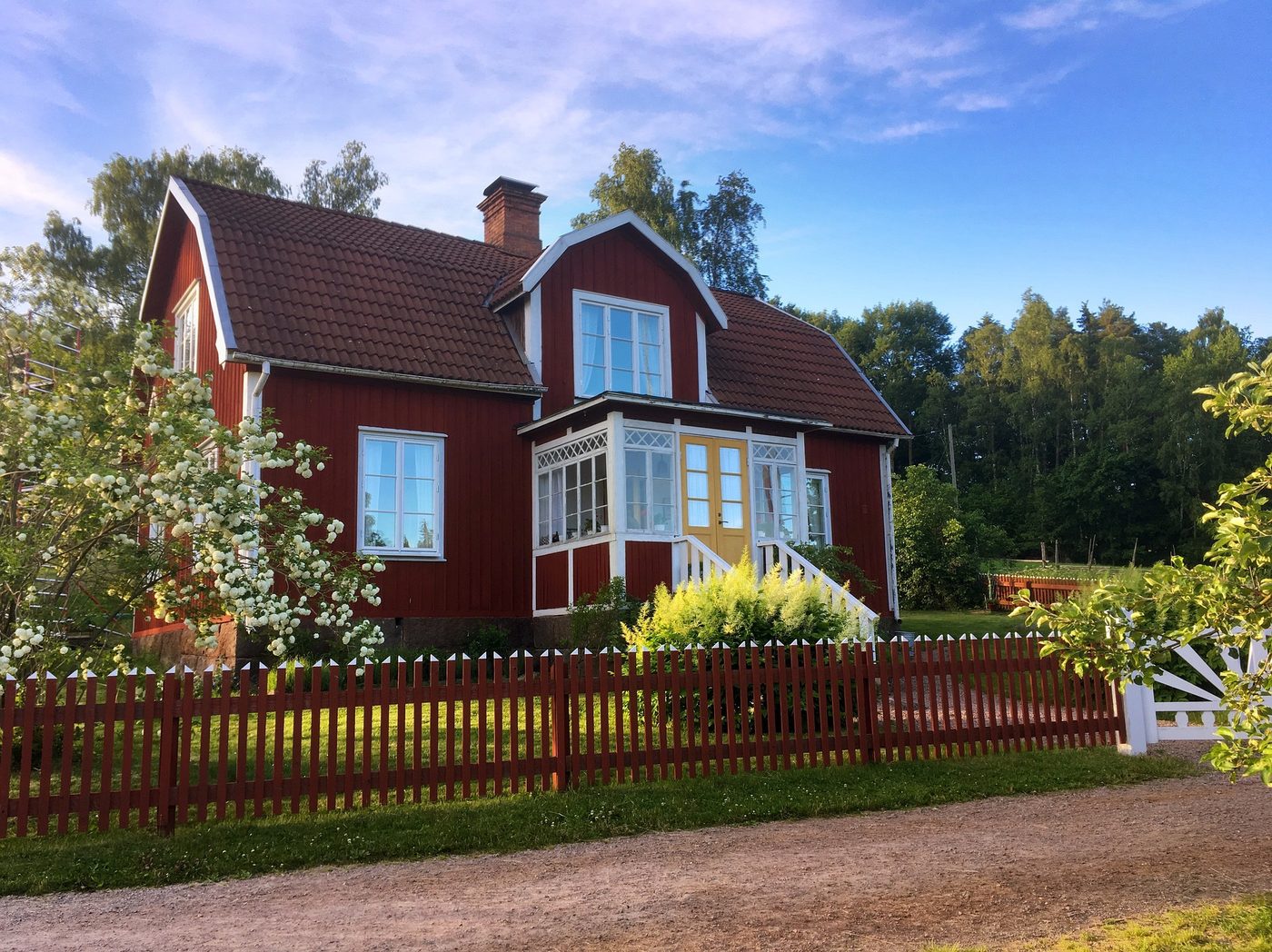 Rött gammalt trähus med vita träfönster