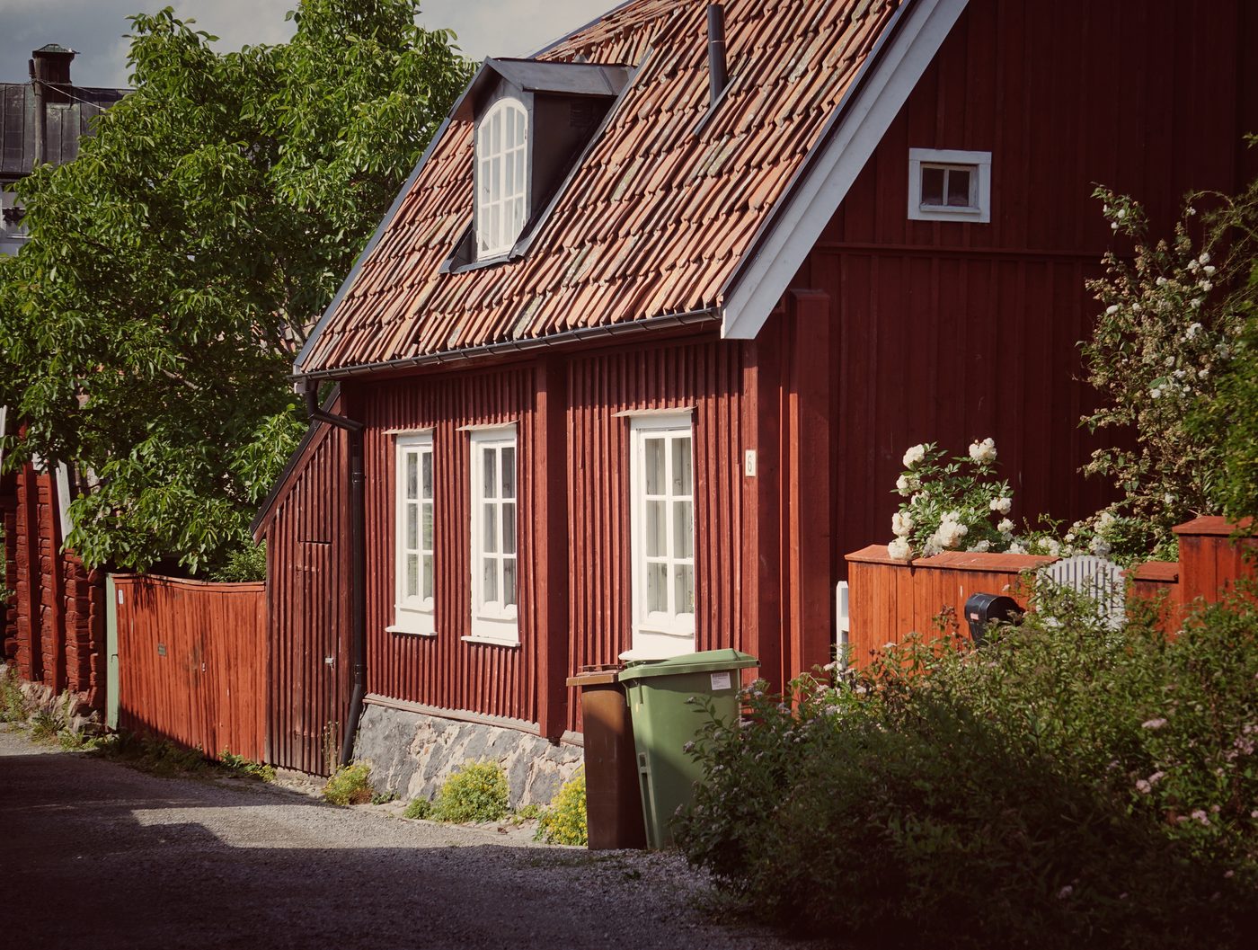 Rött gatuhus i trä med vita träfönster