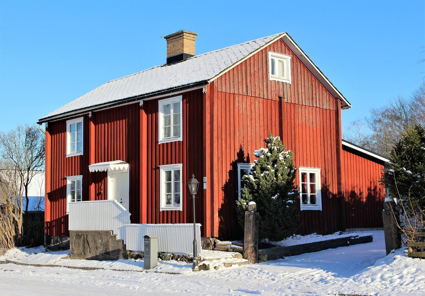 Rött trähus i snöig miljö