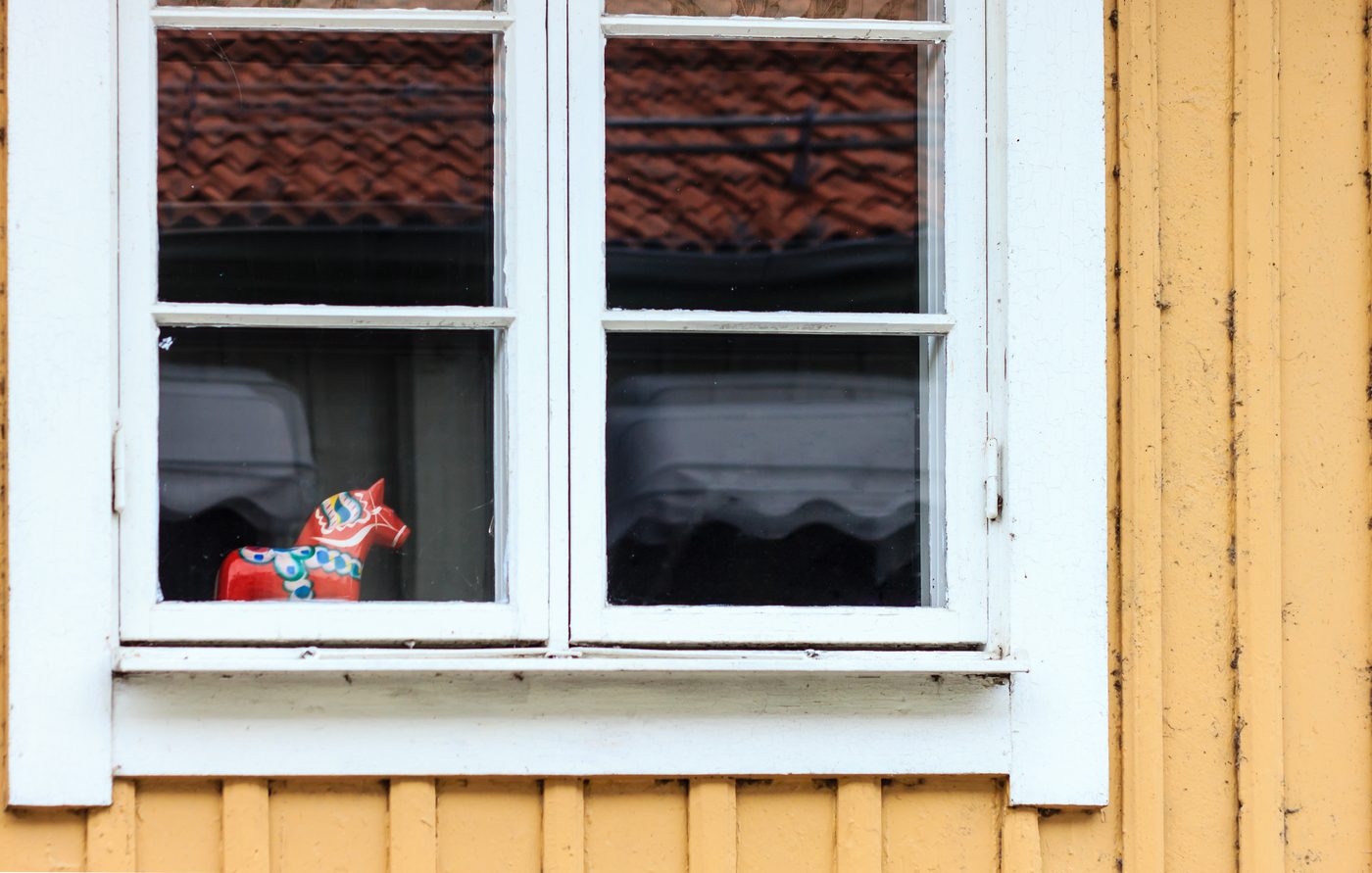 Vitt tvåluftsfönster med dalahäst i fönsterkarmen